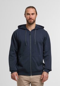 Navy zip-up hoodie with a drawstring hood, front pockets, and ribbed cuffs. Soft fabric with a smooth texture and no visible patterns.