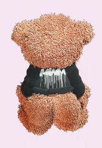 Osito de peluche con suave y esponjosa piel de color naranja. Lleva una camiseta negra con un diseño de goteo blanco en la parte delantera. Forma simple y redonda.