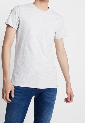 Grå t-shirt med korte ærmer og rund halsudskæring, med en lille lomme på venstre bryst. Fremstillet af et blødt, let stof.