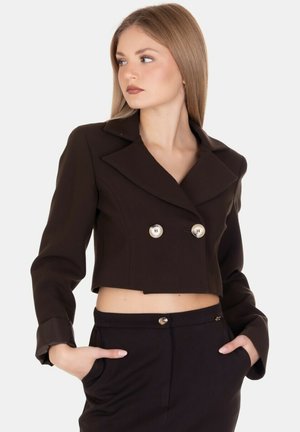 Giacca corta marrone con design doppiopetto, bottoni argentati, ampi revers e maniche lunghe, realizzata in un tessuto liscio.