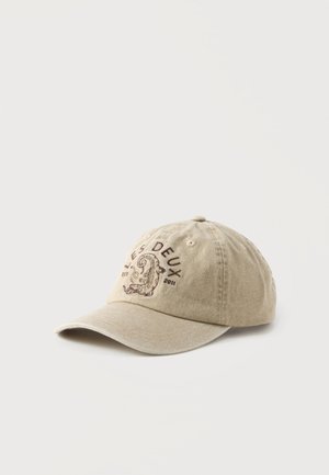Beige Baseballkappe mit gebogenem Schirm, vorne mit ‘‘LES DEUX‘‘-Text und einem bestickten Seepferd-Design vor einem einfarbigen Hintergrund.