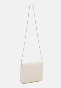 Béžová kabelka přes rameno s hladkou texturou, obdélníkovým tvarem a tenkým zlatým řetízkem. Má zipové zapínání a minimalistický design.