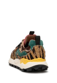 Sneaker multicolore con una tomaia in morbido pelo marrone e nero a fantasia, accenti verdi e suola gialla. Presenta un pratico passante nero e dettagli testurizzati.