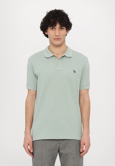 Polo shirt vert clair en coton texturé, avec un col classique, des manches courtes et un petit logo sur la poitrine.