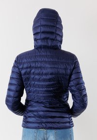 Giacca puffer blu navy con cappuccio e texture a effetto trapuntato orizzontale, caratterizzata da un design aderente e materiale sintetico lucido e elegante.