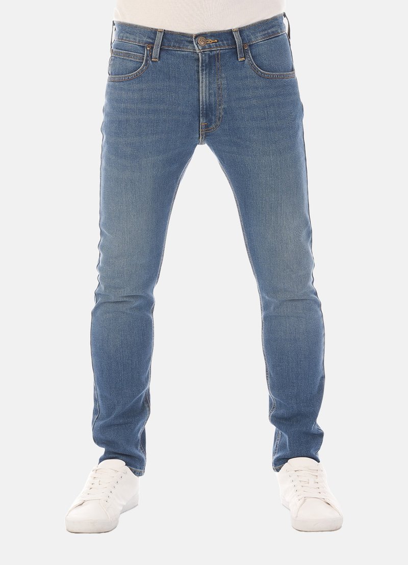 Slim-fit blauwe denim jeans met vijf zakken, riemlussen en subtiele vervaging, gecombineerd met witte sneakers op een neutrale achtergrond.