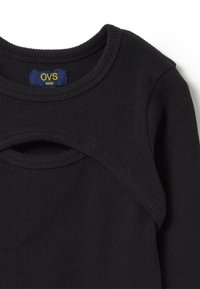 Top lungo a maniche nere a coste con scollatura rotonda e dettaglio a occhiello. Realizzato in tessuto morbido, con un'etichetta che riporta "OVS kids."