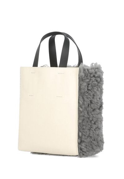 Borsa a spalla con un pannello frontale in pelle crema e un lato in lana grigia testurizzata, caratterizzata da doppi manici neri e una forma rettangolare strutturata.