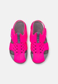 Chanclas sintéticas rosas con parte superior perforada, suela de goma gris, tira en el talón y plantilla texturizada. Diseñadas para su uso en agua y al aire libre.