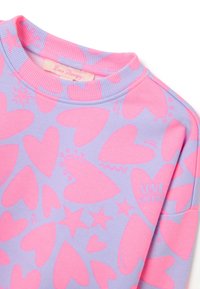 Sudadera morada con un patrón de corazones y estrellas rosas, cuello de canalé y etiqueta "Love Therapy" cosida en el interior. Textura suave.
