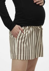 Stribet beige- og brune shorts med elastisk talje, snoretræk og sidelommer, lavet af et blødt, åndbart stof.