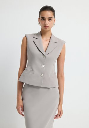 Gray sleeveless blazer with a notched collar, double button closure, and two front pockets. Smooth, structured fabric with tailored fit.