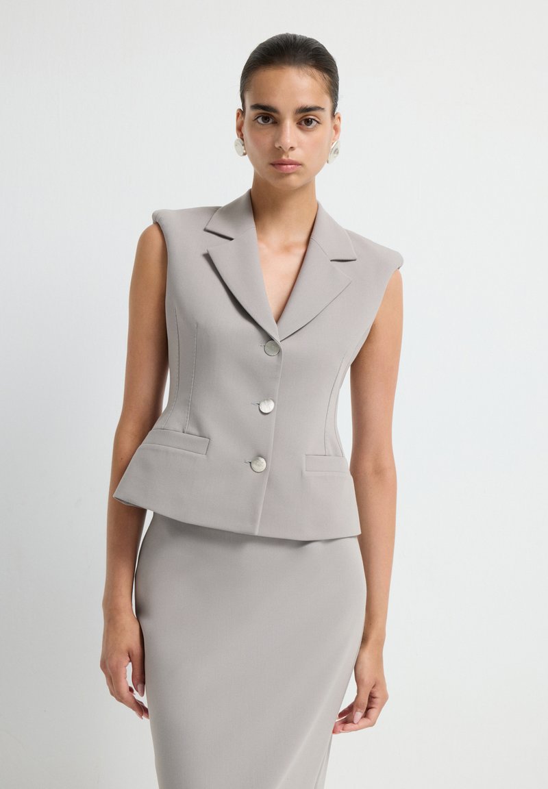 Grauer, ärmelloser Blazer mit Reverskragen, doppelter Knopfleiste und zwei vorderen Taschen. Glattes, strukturiertes Gewebe mit taillierter Passform.