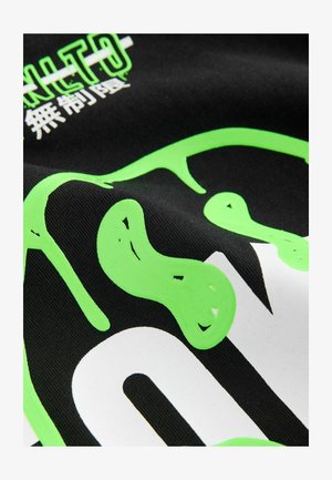 Fekete anyag nagy, fényes fehér és élénk zöld grafikákkal és feliratozással, texturált felülettel és változó vonalvastagságokkal.