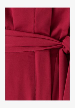 Maroon suknelė su diržu, pasižyminti tekstūruota medžiaga, lygiu paviršiumi ir matomomis siūlėmis. Diržas surištas liemeni.