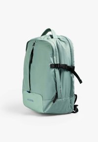 Mochila verde menta con una textura suave, bolsillo externo con cremallera, correas negras ajustables y un logo embellecido en el frente.