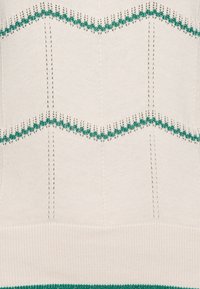 Sweter dziewiarski w kolorze kremowym z zielonymi zygzakowymi paskami. Posiada ściągacze na mankietach i u dołu, teksturowane przeszycia oraz ogólnie gładką powierzchnię.