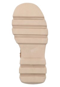 Suela de zapato de goma beige con una superficie texturada y con patrón, que presenta estrías horizontales y una zona de los dedos redondeada.