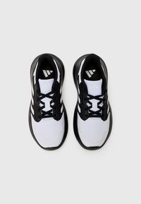 Baskets de sport noir et blanc avec une tige en mesh, semelle épaisse et lacets noirs ; présente des accents de rayures blanches distincts et un logo sur la languette.