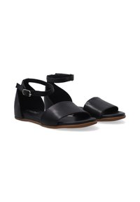 Schwarze Leder-Sandalen mit einem hinteren Knöchelriemen, offener Zehenpartie und flachem Boden, minimalistischem Design und glatter Textur.