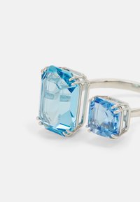 Ring mit zwei rechteckigen blauen Edelsteinen, einer größer und klarer als der andere, eingearbeitet in Silber-Metall mit Krappenfassung.