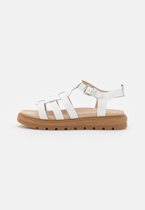 Hvid lædersandal med flere stropper, justerbar side-spænde, polstret indlægssål og tyk brun gummisål med slidbanemønster.