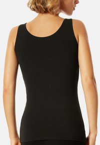 Black tank top with a fitted design, made of soft fabric. Features a rounded neckline and wide straps, showcasing a smooth texture.