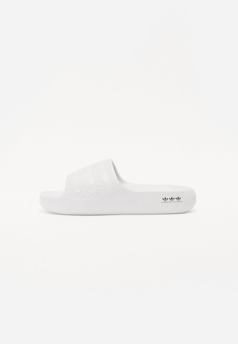 White slide sandal made of synthetic material. A textured upper with horizontal stripes and brand logo on the sole. Smooth, lightweight design.