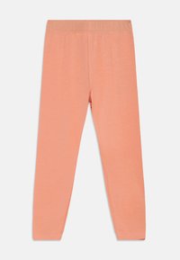 Κολάν σε ροδακινί απόχρωση με απαλό, ελαστικό ύφασμα, που διαθέτει ελαστική μέση και εφαρμοστή γραμμή· χωρίς ορατές ραφές ή σχέδια.