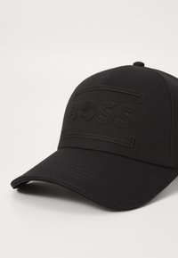 Fekete baseball sapka textúrált anyagból, a frontra Relief "BOSS" logóval és téglalap alakú keret dizájnnal.