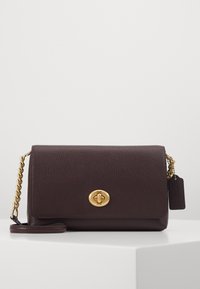 Tumma burgundinpunainen nahkainen olkalaukku, jossa on teksturoitu pinta, kullanväriset metalliosat, ketjureppu ja tunnusomaisella soljella varustettu suljin.