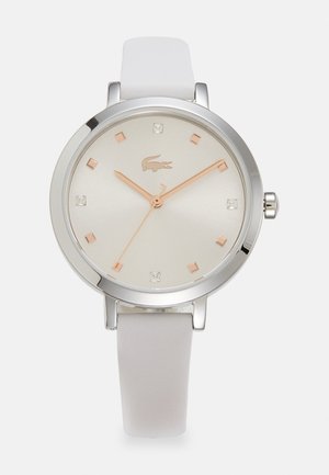 Montre à bracelet en cuir blanc avec un boîtier rond en acier inoxydable, cadran minimaliste argenté, aiguilles en or rose et marqueurs horaires carrés en cristal.