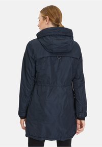 Marineblauer wasserdichter Parka mit Kapuze, tailliertem Schnitt und geknöpften Manschetten. Verfügt über eine glatte Textur und eine hintere Belüftungsöffnung.