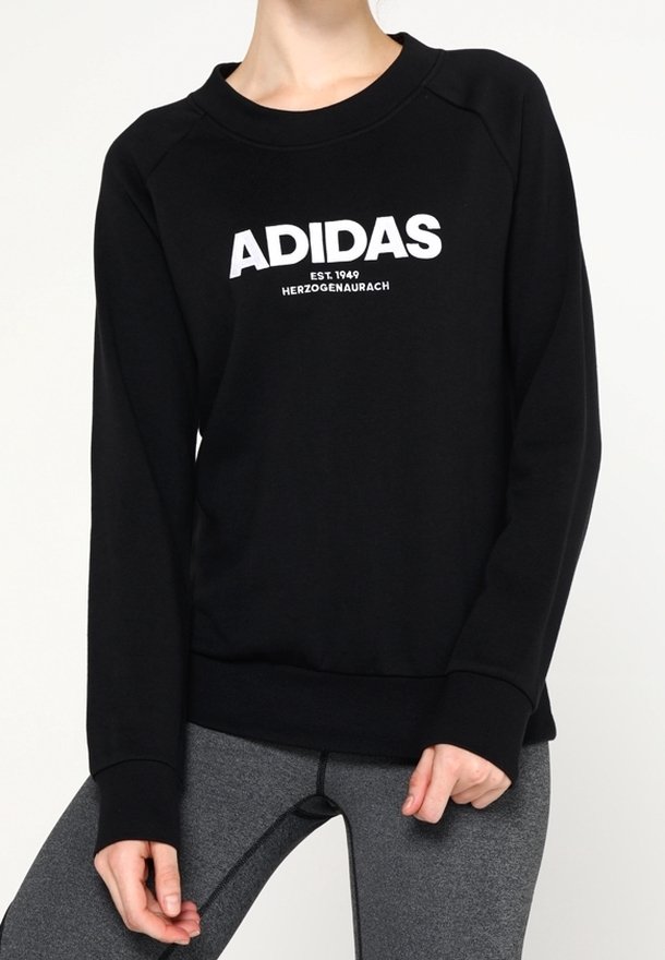 Sweat-shirt noir avec logo blanc "ADIDAS" et texte "EST. 1949 HERZOGENAURACH". Dispose de poignets et d'un col côtelés avec une coupe décontractée.