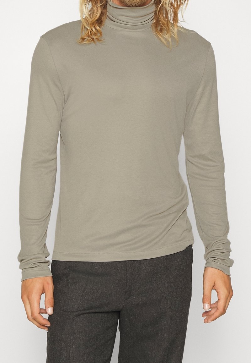 Maglione a maniche lunghe con collo alto in grigio chiaro, realizzato in un tessuto morbido con una vestibilità aderente, caratterizzato da un design semplice e liscio con maniche attillate.
