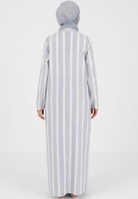 Gestreiftes Maxikleid in hellblau und weiß, mit langen Ärmeln und geradem Schnitt. Weicher Stoff mit glatter Textur und minimaler Detailierung.