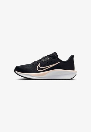 Scarpa sportiva nera con tomaia texturizzata, dotata di un sottopiede bianco e una swoosh rosa chiaro sul lato. Design leggero con suola nera.