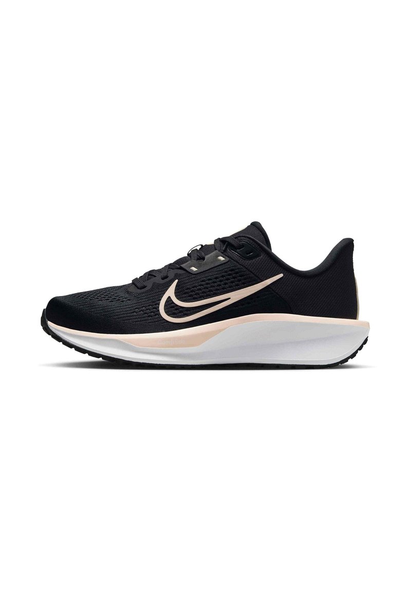 Musta urheilukenkä, jossa on teksturoitu päällinen, valkoinen välipohja ja vaaleanpunainen swoosh sivussa. Kevyt muotoilu mustalla pohjalla.