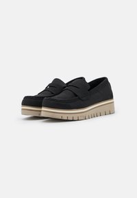 Black suede loafers with a wide band across the front and a cushioned insole. Features a contrasting beige rubber sole with a textured underside.