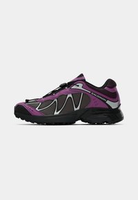 Purple and black athletic shoe with mesh upper, rubber outsole, and elastic laces. Features textured accents and a streamlined design.