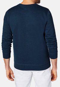 Granatowy sweatshirt wykonany z miękkiego materiału, z długimi rękawami, ściągaczami na mankietach i ściągaczem u dołu. Brak widocznych wzorów lub akcentów.