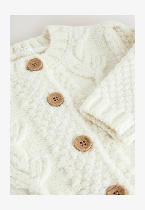 Cardigan in maglia crema con motivi testurizzati, dotato di bottoni in legno e colletto a risvolto. Materiale morbido e spesso, ideale per stratificare.