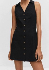 Robe noire sans manches avec un col en V, fermeture à boutons sur le devant et détails structurés aux épaules ; fabriquée en tissu lisse avec une silhouette cintrée.