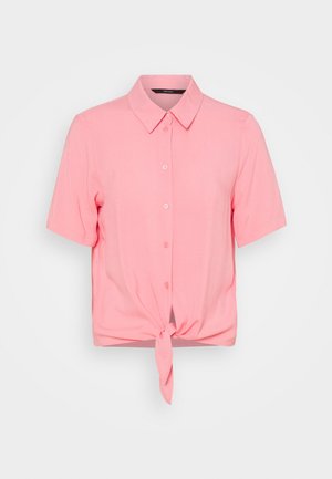 Chemise rose à manches courtes, boutonnée, avec col et nœud devant sur fond uni.