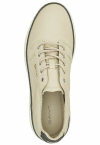 Beige Leinensneaker mit runder Zehenpartie, Schnürdesign, dezentem Logo an der Seite und kontrastierendem dunklen Rand entlang der Sohle.