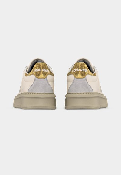 Ζευγάρι ανοιχτό μπεζ αθλητικά παπούτσια με παχιά σόλα, γκρι πάνελ φτέρνας από σουέντ και μεταλλικά χρυσά περιλαίμια με τη σήμανση "roberto cavalli" στο πίσω μέρος.
