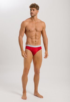 Rote Baumwollslips mit einem grauen Bund, der den Markennamen trägt. Glatte Textur, klassischer Slip-Schnitt und anliegender Stil.