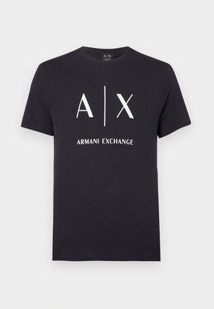 Marineblå bomulls-T-skjorte med kortermet, med hvit trykt logo "A|X ARMANI EXCHANGE" i midten og rund hals.