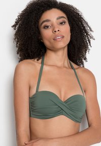 Olivově zelený bikinový top s designem s otočeným předním dílem, nastavitelné halter ramínka a měkkou, hladkou látku. Bez viditelného kovového materiálu nebo ozdob.