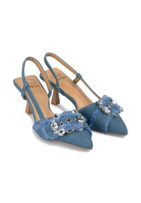 Jeansowe wysokie sandały na obcasie z wąskimi czubkami. Posiadają niebieski materiał, frędzle oraz dekoracyjny akcent z cyrkoniami.